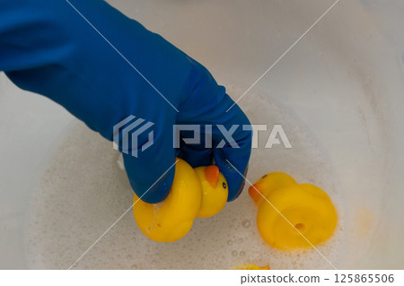 Thoroughly Cleaning Rubber Duck Toys Using Soapy Water for Hygiene and Safety Enjoyment 125865506