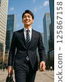 A male new employee starting a new life in a sunny business district 125867158