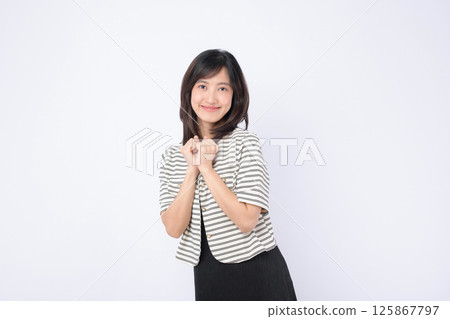 Southeast asian woman smiling warmly in striped jacket posing happily for advertising with clean white background and natural expression Southeast asian woman smiling warmly in striped jacket posing happily for advertising with clean white background and natural expression 125867797