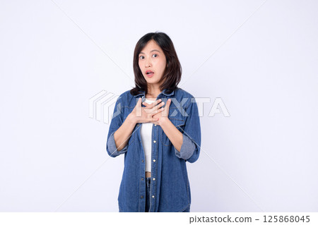 Southeast asian woman expressing surprise and emotion in advertising with casual denim clothing on plain white background 125868045