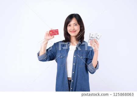 Southeast Asian woman smiling holding credit card and cash money showing internet banking and mobile payment application concept for financial transaction and digital economy 125868063