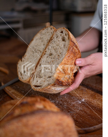 Artisan Sourdough Bread in Hand - Fresh from the Oven. Artisan Sourdough Bread in Hand - Fresh from the Oven. 125868318