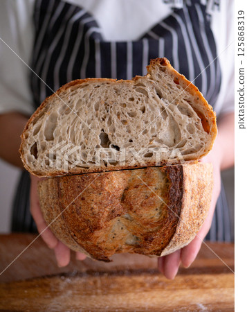 Baker Presenting Homemade Sourdough. Baker Presenting Homemade Sourdough. 125868319