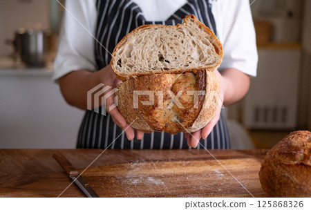 Baker Presenting Homemade Sourdough. Baker Presenting Homemade Sourdough. 125868326
