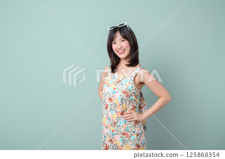 Southeast asian woman smiles confidently wearing colorful dress and sunglasses showing creative spirit as small business owner in retail and online store startup industry shopping Southeast asian woman smiles confidently wearing colorful dress and sunglasses showing creative spirit as small business owner in retail and online store startup industry shopping 125868354