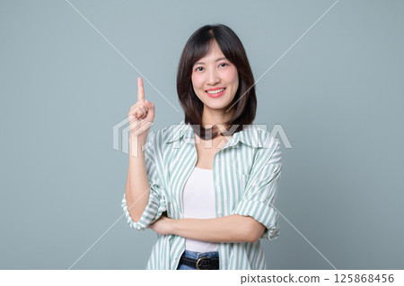Southeast asian woman smiles confidently while pointing up showing creative ideas for her small business startup in retail and online store industry with shopping focus 125868456