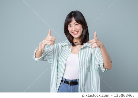 Southeast asian woman shows thumbs up with bright smile representing small business owner in retail and online store startup industry with creative energy and confidence 125868463