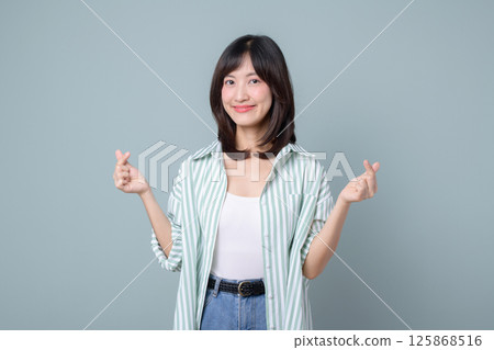 Creative southeast asian woman smiles confidently showing finger heart gesture symbolizing love and support for small business owner in retail and online store startup industry Creative southeast asian woman smiles confidently showing finger heart gesture symbolizing love and support for small business owner in retail and online store startup industry 125868516