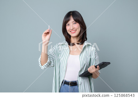 Southeast asian woman small business owner is smiling creatively while holding tablet and pen representing retail startup and online store industry success Southeast asian woman small business owner is smiling creatively while holding tablet and pen representing retail startup and online store industry success 125868543