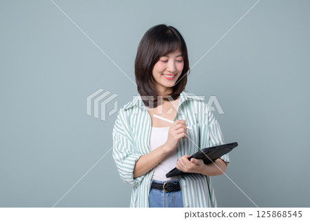 Southeast asian woman is small business owner working creatively on tablet for her online retail store startup in shopping and creative industry with happy expression 125868545