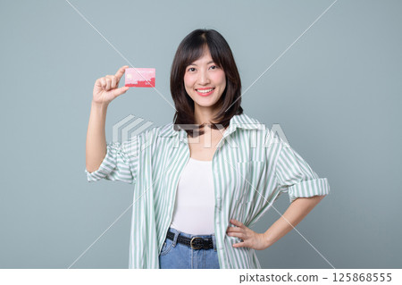 Southeast asian woman shopping online holding credit card smiling happily in casual outfit 125868555