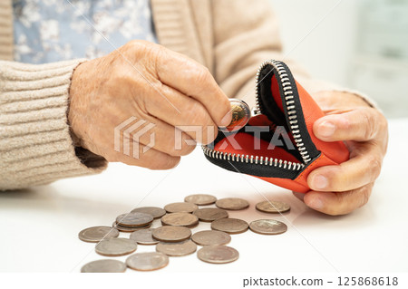Asian senior or elderly old lady woman holding counting coin money in purse. Poverty, saving problem in retirement. Asian senior or elderly old lady woman holding counting coin money in purse. Poverty, saving problem in retirement. 125868618