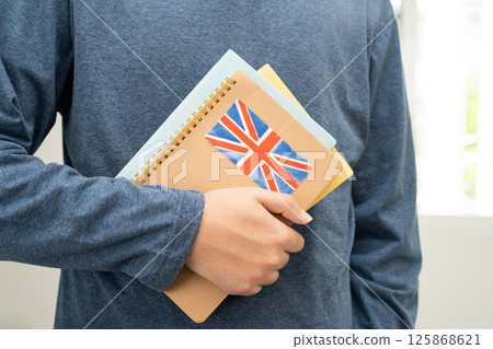Learn English language, Asian teenage student hold book with flag in course at school. 125868621