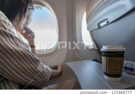 Coffee and a smartphone on the table of an airplane seat Coffee and a smartphone on the table of an airplane seat 125868777