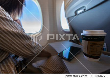 Coffee and a smartphone on the table of an airplane seat 125868779