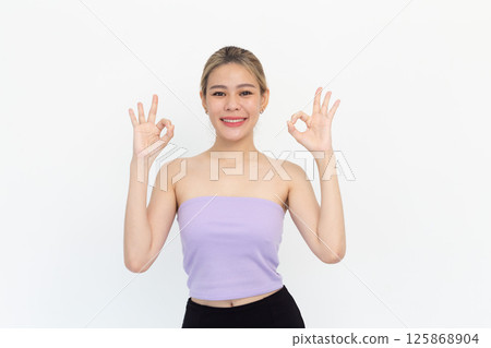 Portrait of Happy asian young woman smiling against made finger thumbs up OK gesture on white background 125868904