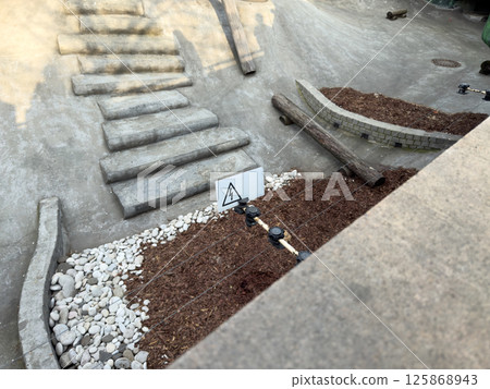 Outdoor electric fence installation with a clear high voltage warning sign. The setup highlights public safety measures in landscaped or urban play environments Outdoor electric fence installation with a clear high voltage warning sign. The setup highlights public safety measures in landscaped or urban play environments 125868943