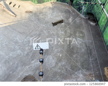 Electric fence installed inside a zoo animal enclosure to ensure safety and prevent direct contact between visitors and animals. A clear example of responsible zoo infrastructure Electric fence installed inside a zoo animal enclosure to ensure safety and prevent direct contact between visitors and animals. A clear example of responsible zoo infrastructure 125868947