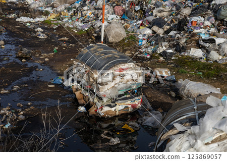 Piles of trash and debris clutter a roadside in a neglected area, highlighting environmental concerns and poor waste management practices Piles of trash and debris clutter a roadside in a neglected area, highlighting environmental concerns and poor waste management practices 125869057