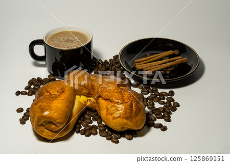 Delicious pastries with a cup of coffee, cinnamon and coffee beansDelicious pastries with a cup of coffee, cinnamon and coffee beans 125869151