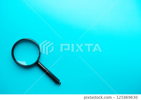 Magnifying glass on blue background. Top view. Flat lay. Copy space. 125869630