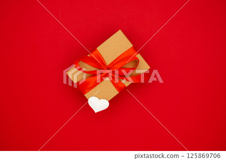 On red background craft box with red ribbon. A gift for Valentine's Day 125869706