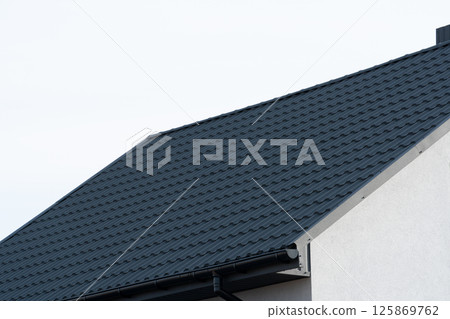 Roof of a new home. Black metal tile roof Roof of a new home. Black metal tile roof 125869762