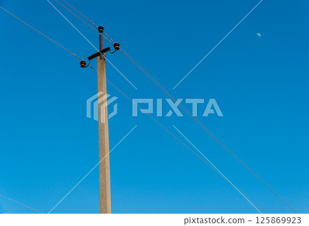 Old electric pole with wires used for electricity traffic with clear blue sky. Power electric pole Old electric pole with wires used for electricity traffic with clear blue sky. Power electric pole 125869923