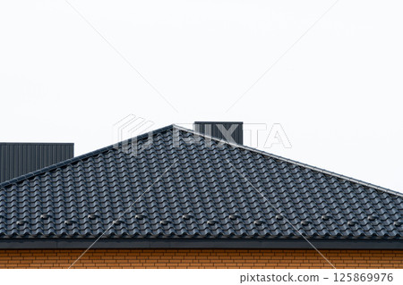 Roof structure covered with black metal tiles. Modern types of roofing materials. Modern housing construction 125869976