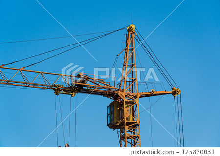 Construction crane on the background of the blue sky 125870031