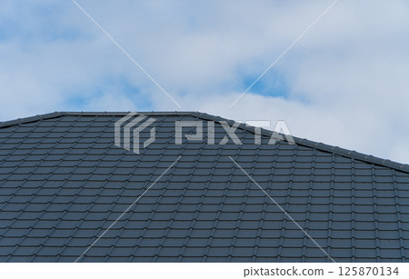 Black metal tile on the roof of the house. The material for the roof 125870134