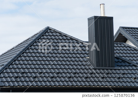 House roof top covered with black metallic shingles. Beautiful modern roof of the house 125870136