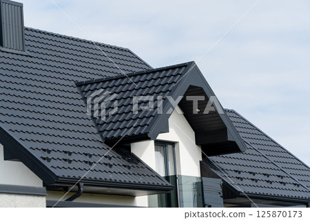 The roof of a modern new house. Tiled covering of building. Modern European house 125870173