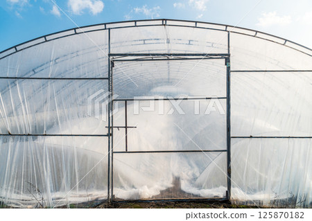 Soil greenhouse with plastic film outside view Soil greenhouse with plastic film outside view 125870182