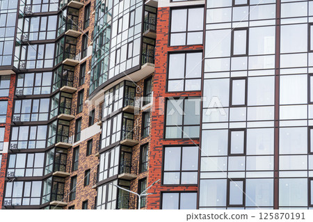 External view of modern complex of new apartment residential buildings. Building made of red and brown brick. Part of urban real estate External view of modern complex of new apartment residential buildings. Building made of red and brown brick. Part of urban real estate 125870191