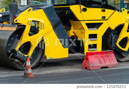 Vibratory road roller. Close-up of the work of road machinery Vibratory road roller. Close-up of the work of road machinery 125870251