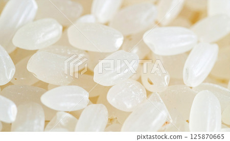 Japanese rice grains with a white and slightly translucent texture. Ideal for concepts related to healthy food, Asian cuisine, cooking ingredients, and traditional nutrition 125870665