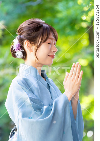 身穿浴衣的女性雙手合十在神社祈禱 125871254