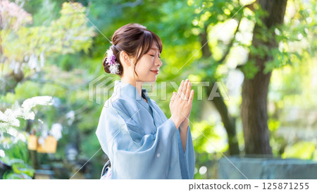 身穿浴衣的女性雙手合十在神社祈禱 125871255
