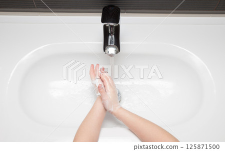 washing hands with soap. Little girl is washing her hands to prevent virus and germs. washing hands with soap. Little girl is washing her hands to prevent virus and germs. 125871500
