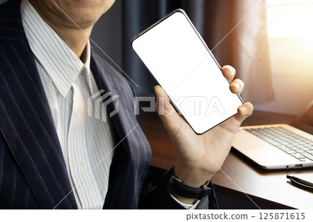 Businessman holding a smartphone. Smartphone screen on white background. Businessman holding a smartphone. Smartphone screen on white background. 125871615