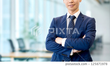 Smiling male businessman with arms folded Smiling male businessman with arms folded 125871978
