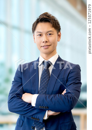Smiling male businessman with arms folded 125871979
