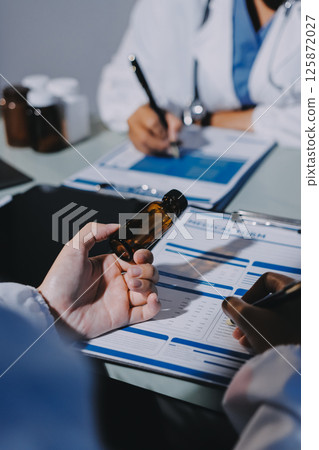 Male and female doctors are having a meeting in a hospital room. 125872027