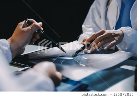 Male and female doctors are having a meeting in a hospital room. Male and female doctors are having a meeting in a hospital room. 125872035