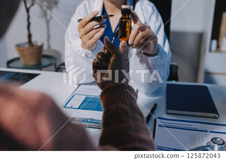 Specialized doctor is explaining taking medicine to a patient. Health and medicine consultation. 125872043