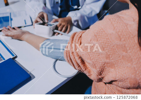 Nurse measuring blood pressure of elderly woman at table, closeup. Assisting senior generation 125872068