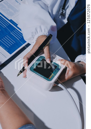 Nurse measuring blood pressure of elderly woman at table, closeup. Assisting senior generation Nurse measuring blood pressure of elderly woman at table, closeup. Assisting senior generation 125872076