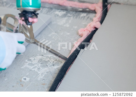 Applying mounting foam to floor insulation channel 125872092