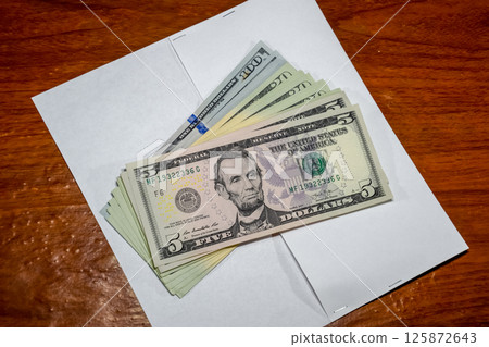 Dollars on table with an envelope. Money in an envelope. U.S. dollars. Dollars on table with an envelope. Money in an envelope. U.S. dollars. 125872643